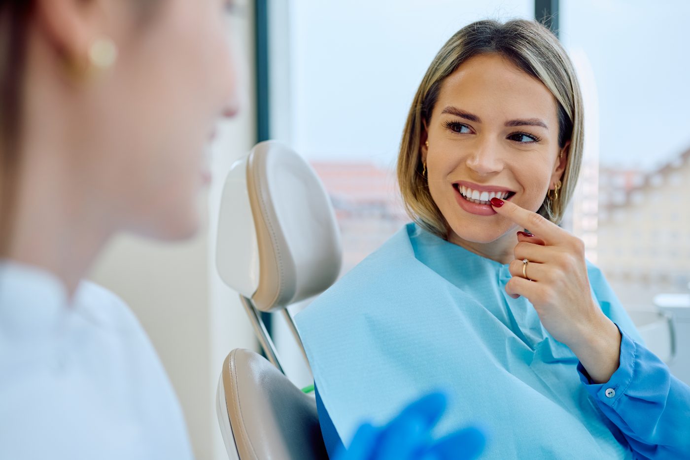 A dental patient smiling in the treatment chair on the practice's current website